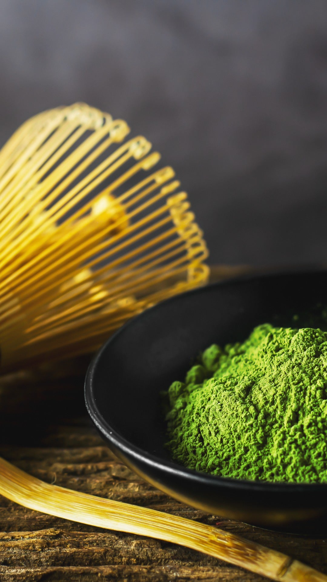 Matcha, green tea powder, bamboo scoop and whisk, chashaku, chasen, wooden table, dark background